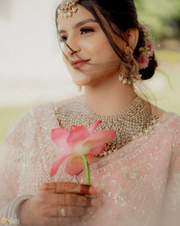 A bride in pastel holding a pink lotus