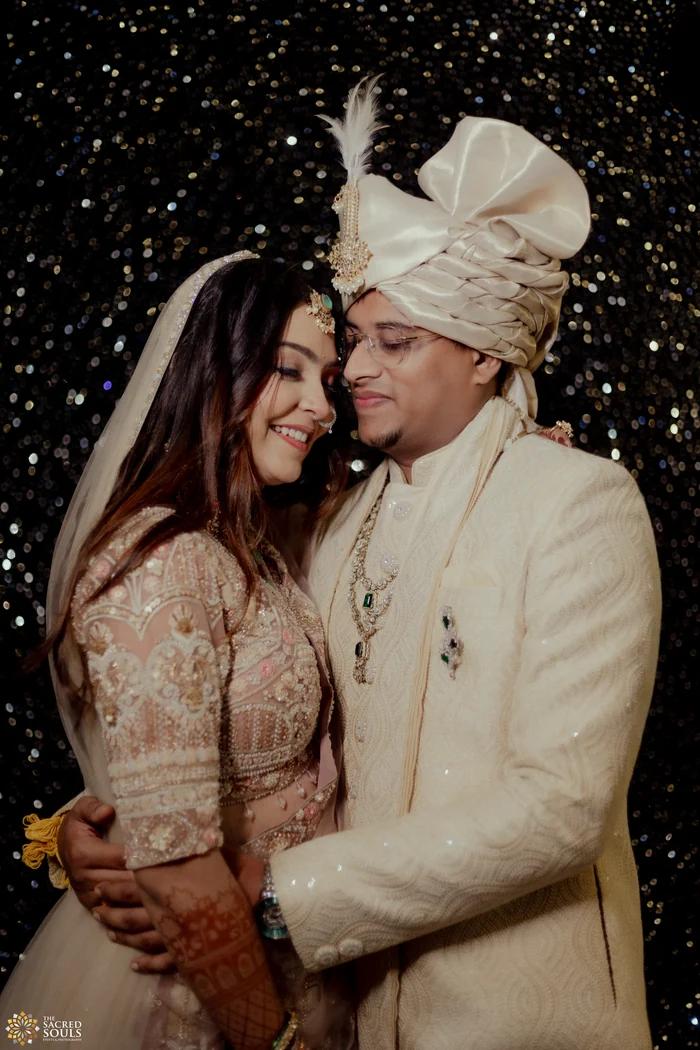 A couple holding each other under falling sparkles at night