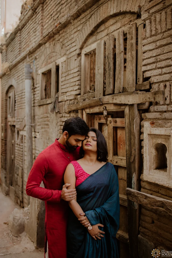 A couple embracing by an old carved building