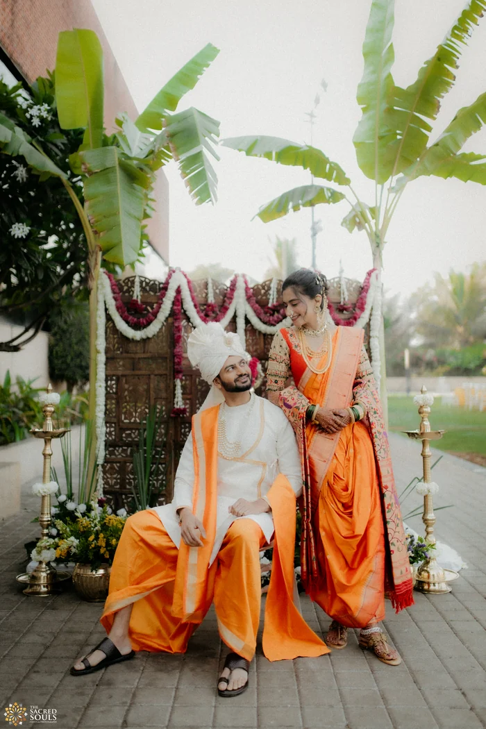 A couple in orange and white sitting on a decorated swing
