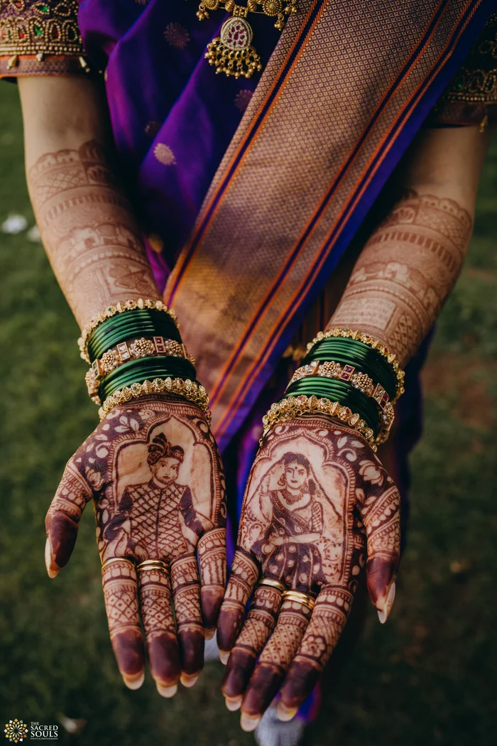Close-up of a bride’s mehndi hands and green bangles