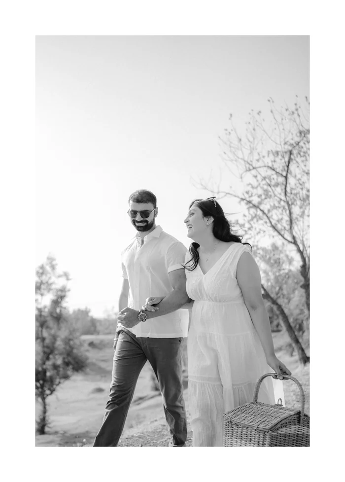 A black-and-white photo of a couple walking with a basket