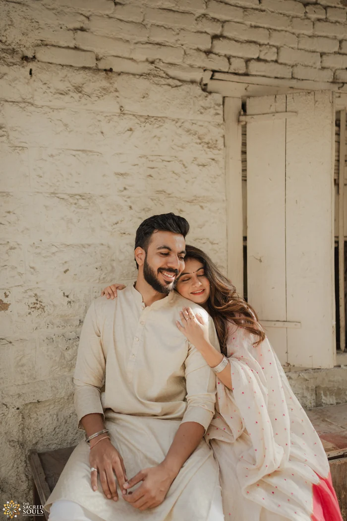 A couple sitting against an old whitewashed wall
