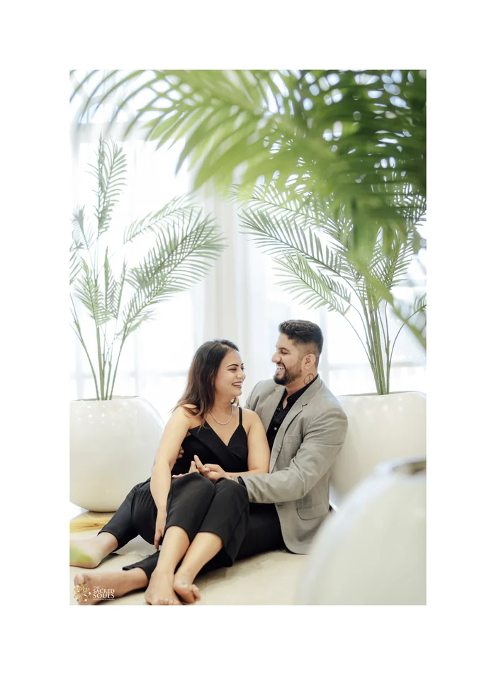 A couple relaxing in a bright room full of plants