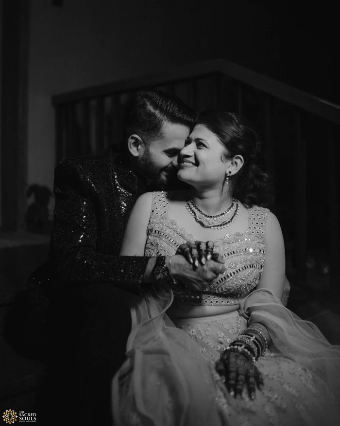 A black-and-white photo of a couple laughing on a sofa