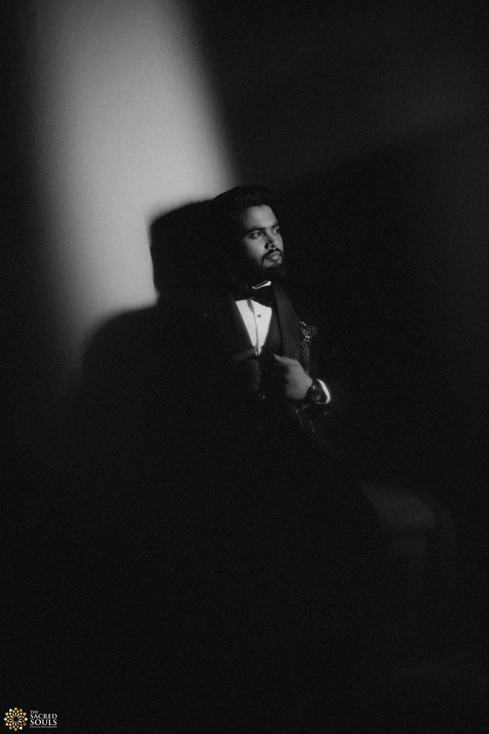 A groom in shadow by a window