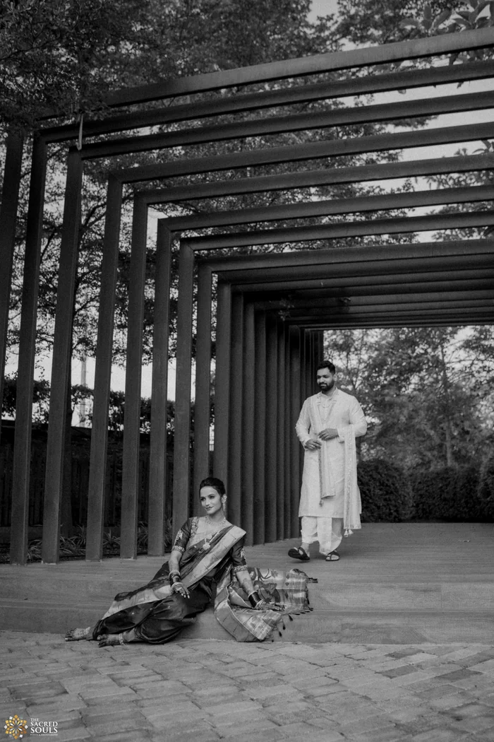 A black-and-white photo of a couple under a slatted roof