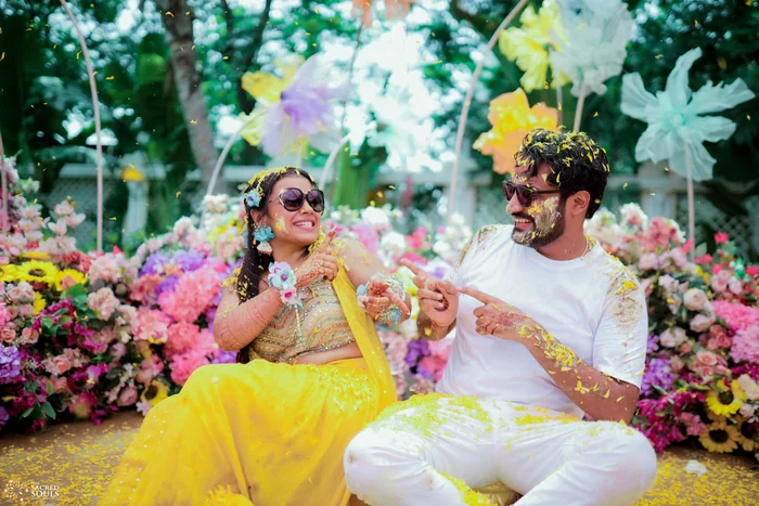 A couple laughing among colourful flowers