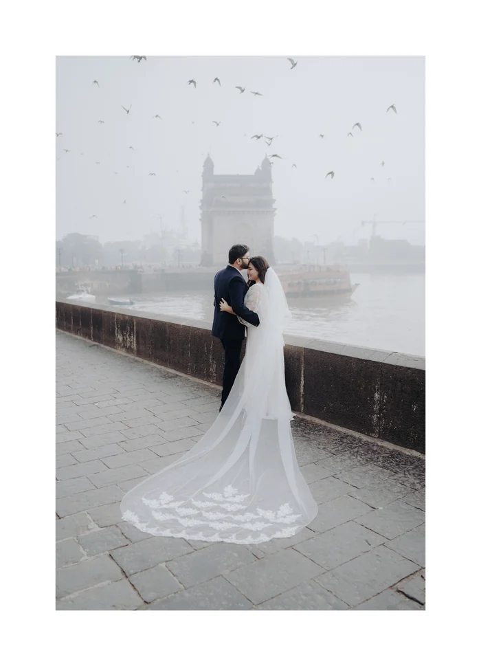 A couple in a long white veil by the sea in Mumbai
