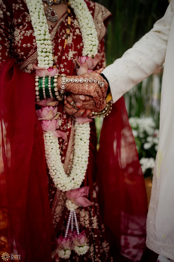 Close-up of the couple’s hands and varmalas