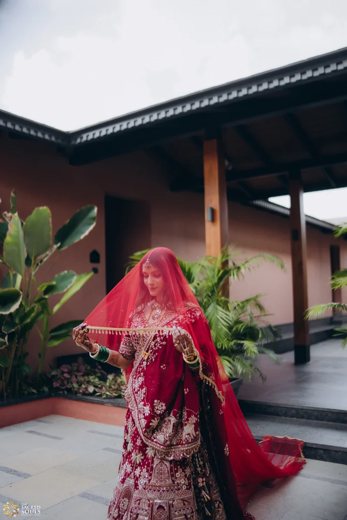 A bride in red walking past a cottage