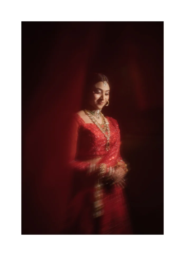 A bride in red against a deep red backdrop