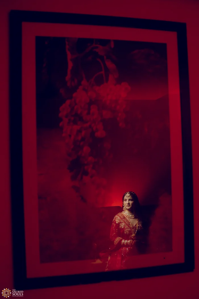 A bride framed in a red-lit doorway