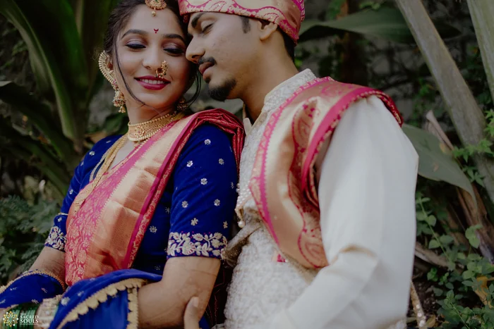 A bride in a blue Paithani leaning on her groom
