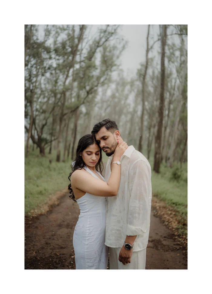 A couple holding each other on a forest path