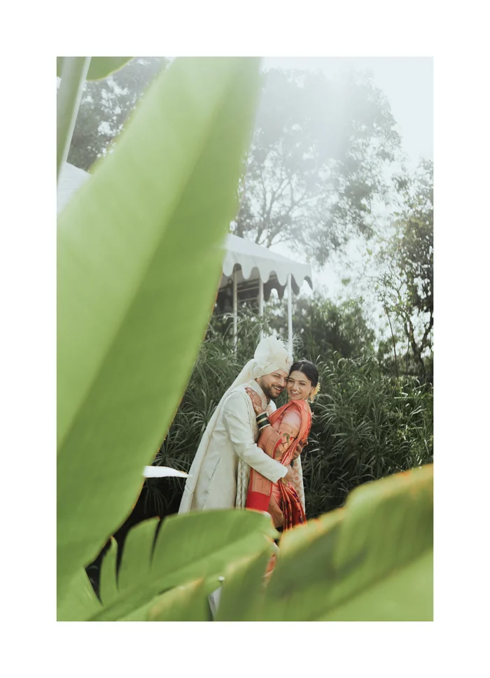 A couple framed by large green leaves