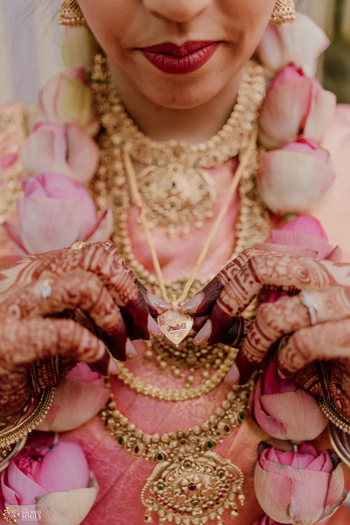 Close-up of a bride’s jewellery and mehndi hands