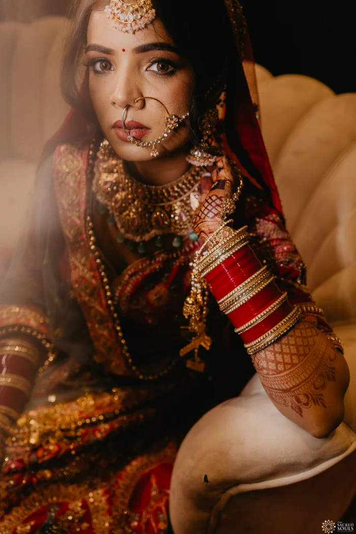 A bride in red resting her chin on her hand