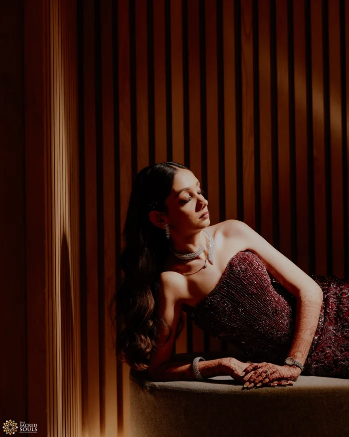 A woman lounging in a gown against wooden slats
