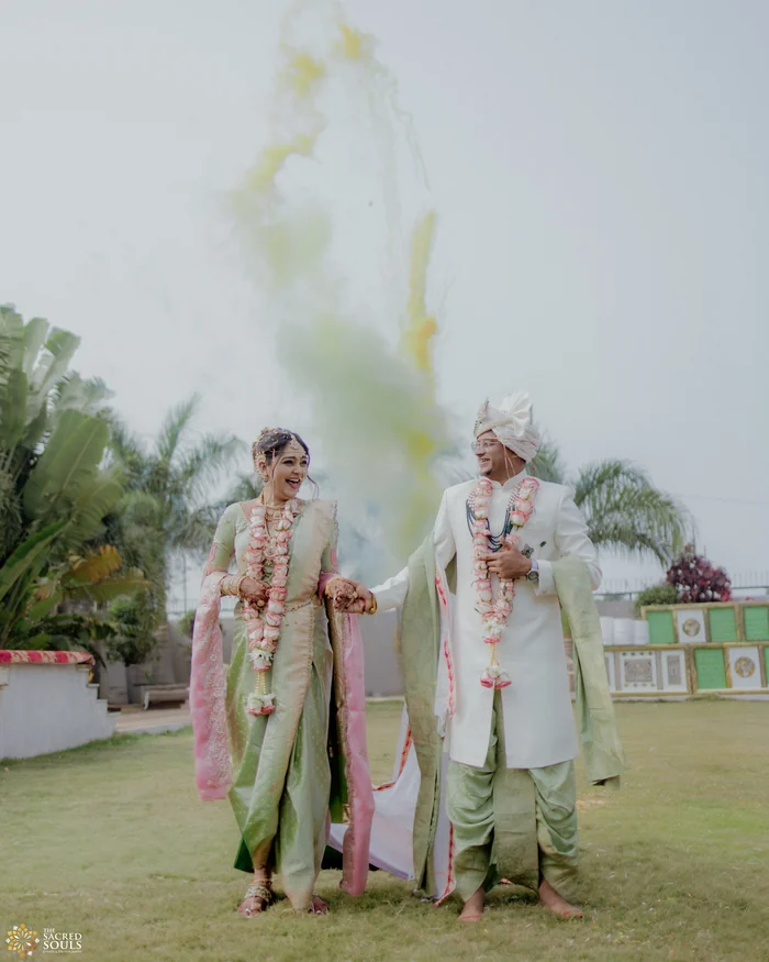 A couple walking through pastel smoke on a lawn