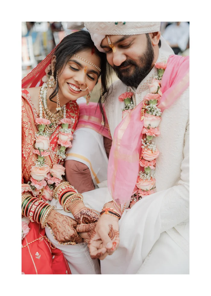 A bride and groom smiling, showing their mehndi